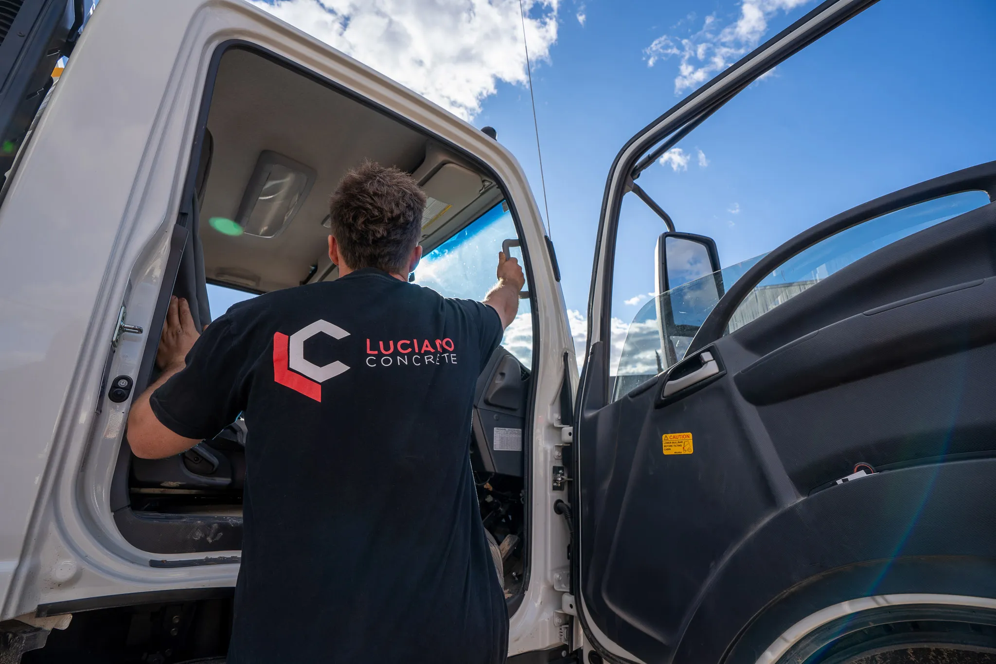 Worker entering a Luciano Concrete truck.