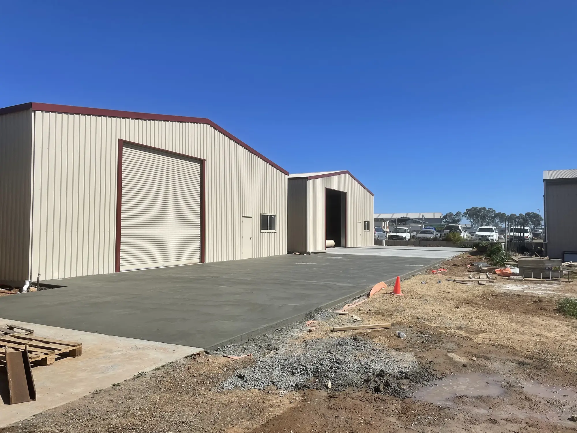 Plain concrete outside a large warehouse.
